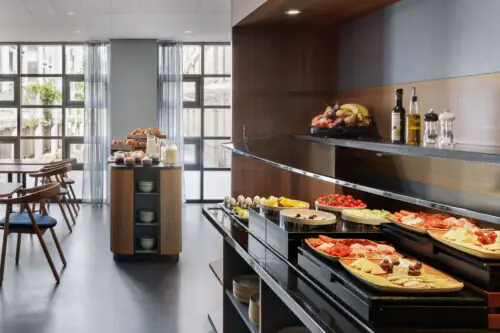 A buffet table filled with various breakfast foods in the breakfast room at Hotel La Pergola.  