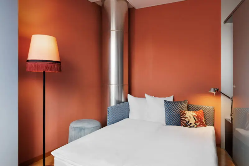 Family room at Hotel La Pergola with a bed and a lamp, creating a warm atmosphere.  